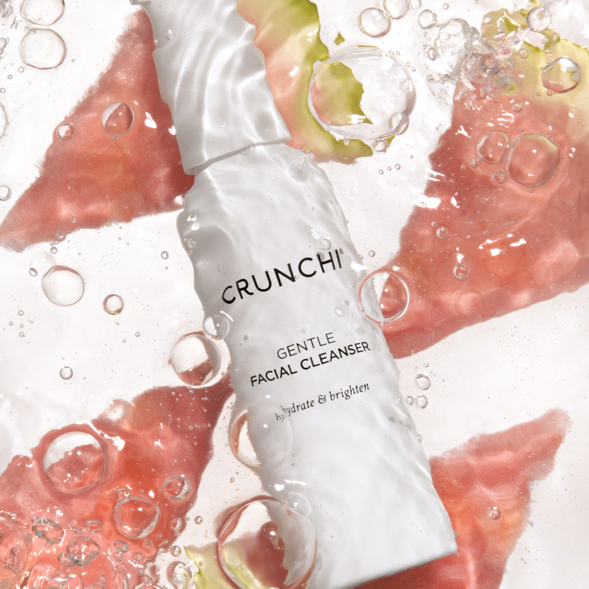 CRUNCHI Gentle Facial Cleanser with fruit slices and bubbles on a light background