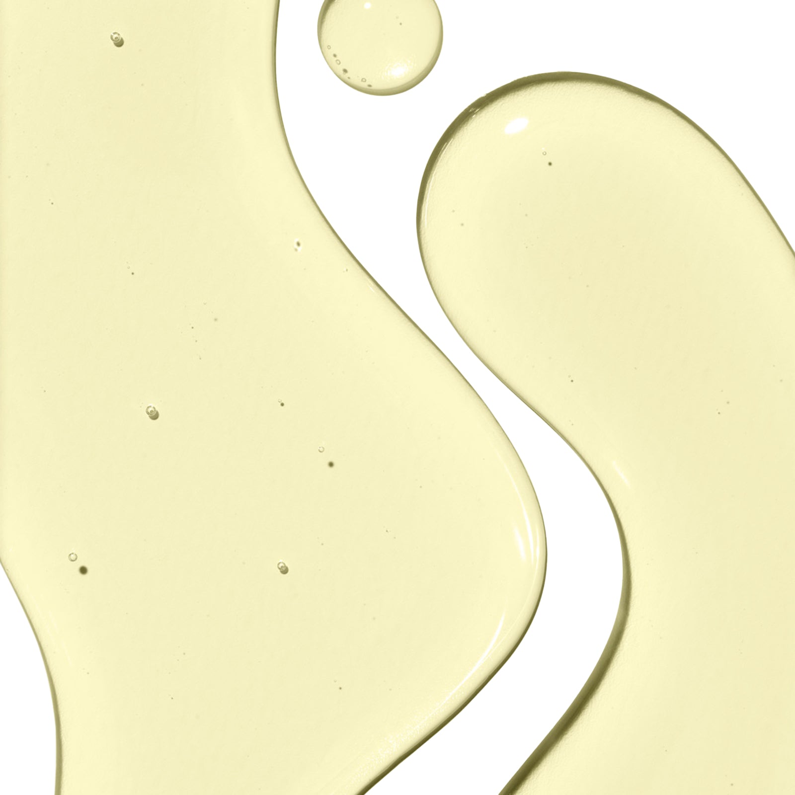 Close-up of yellow liquid droplets on a white background