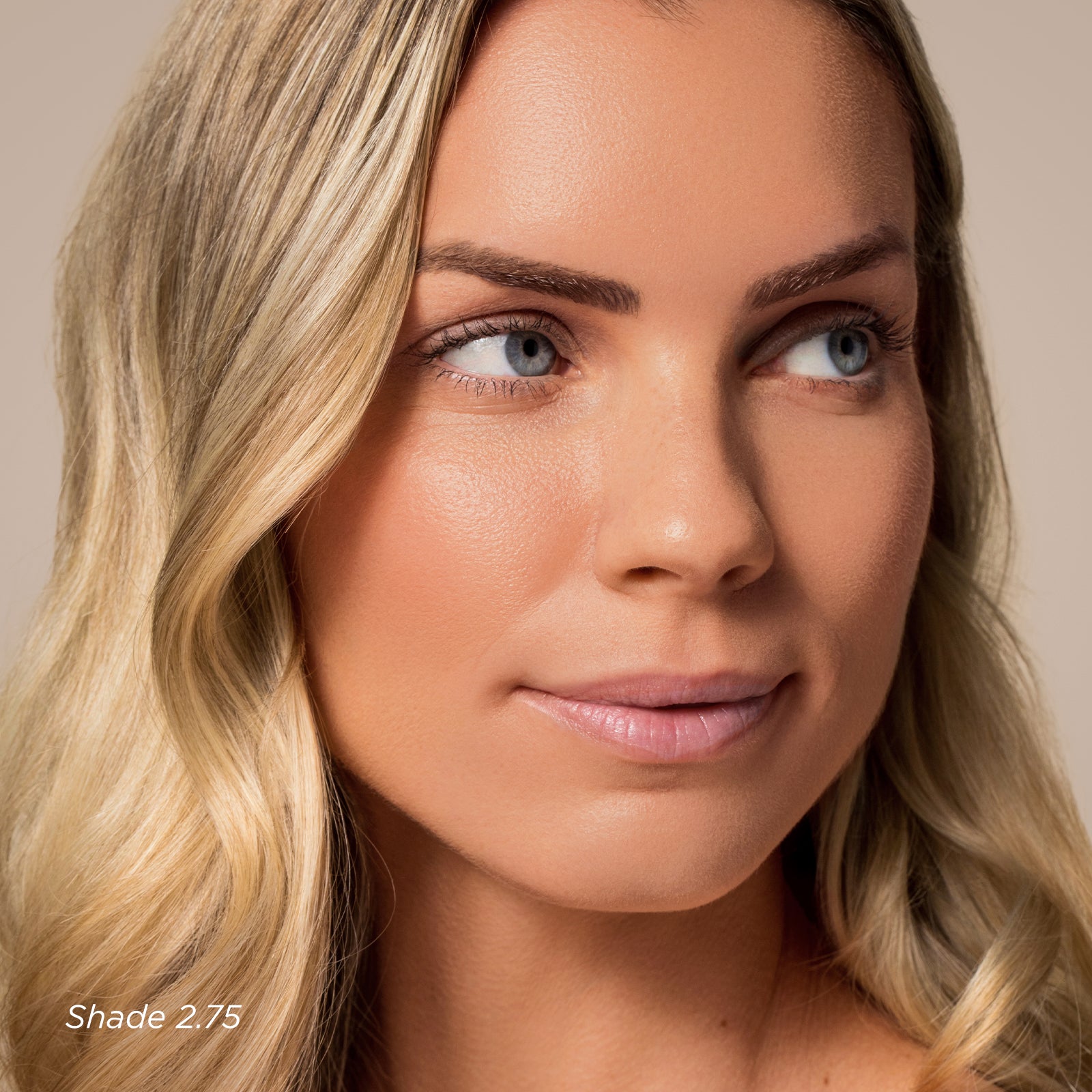 Close-up of a woman with blonde hair and blue eyes on a beige background