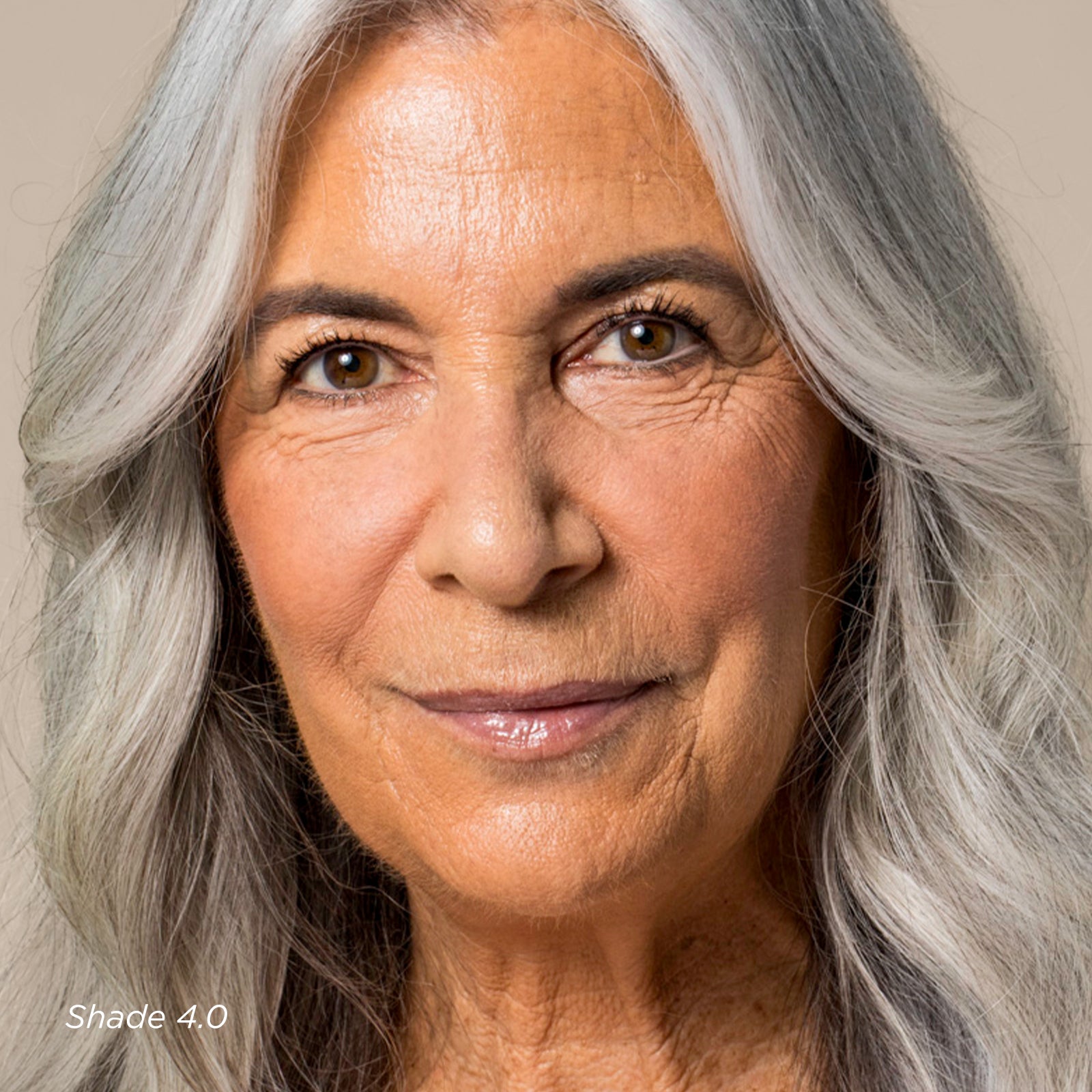 Close-up of a woman with gray hair against a neutral background