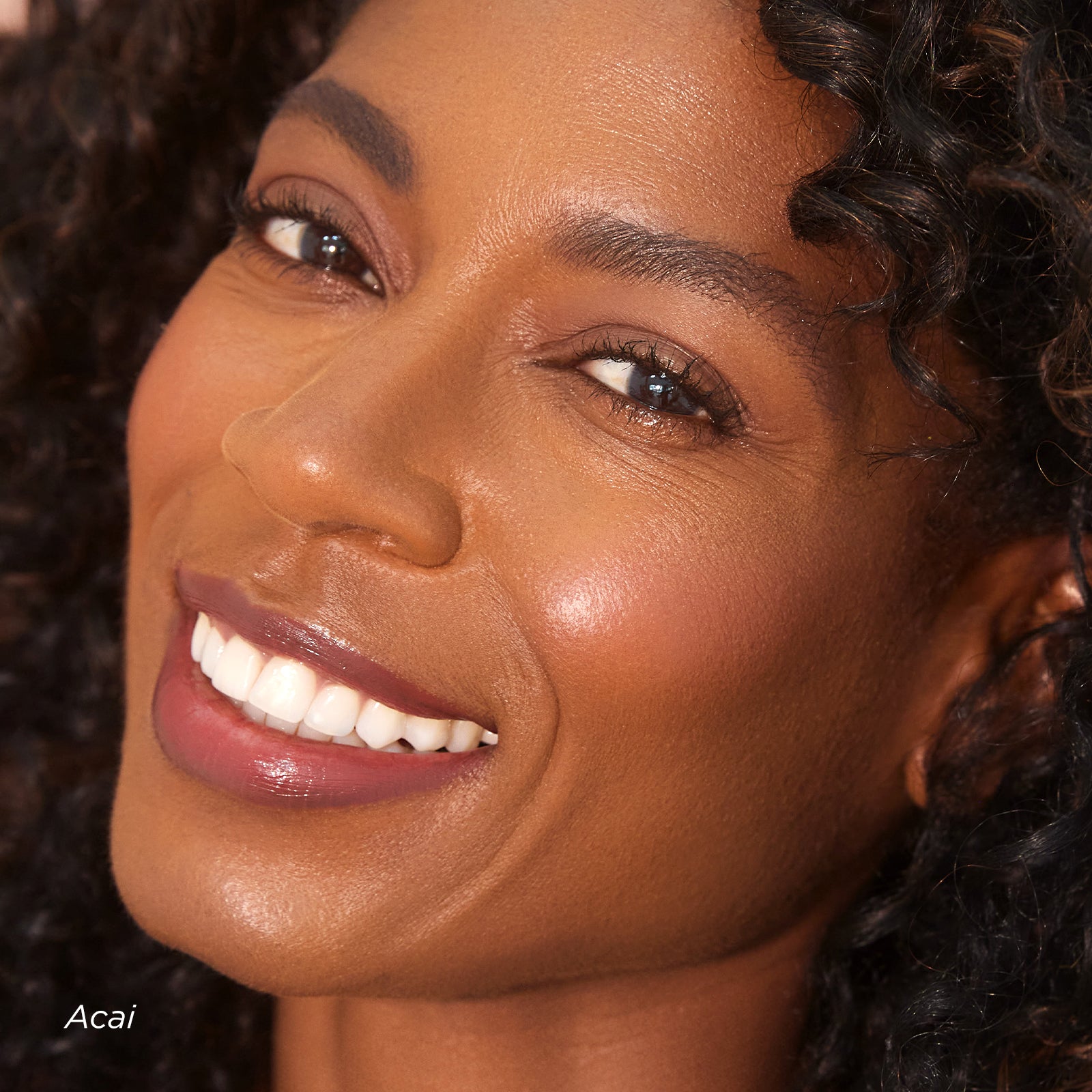 Close-up of a woman's face with a focus on her smile and skin texture.