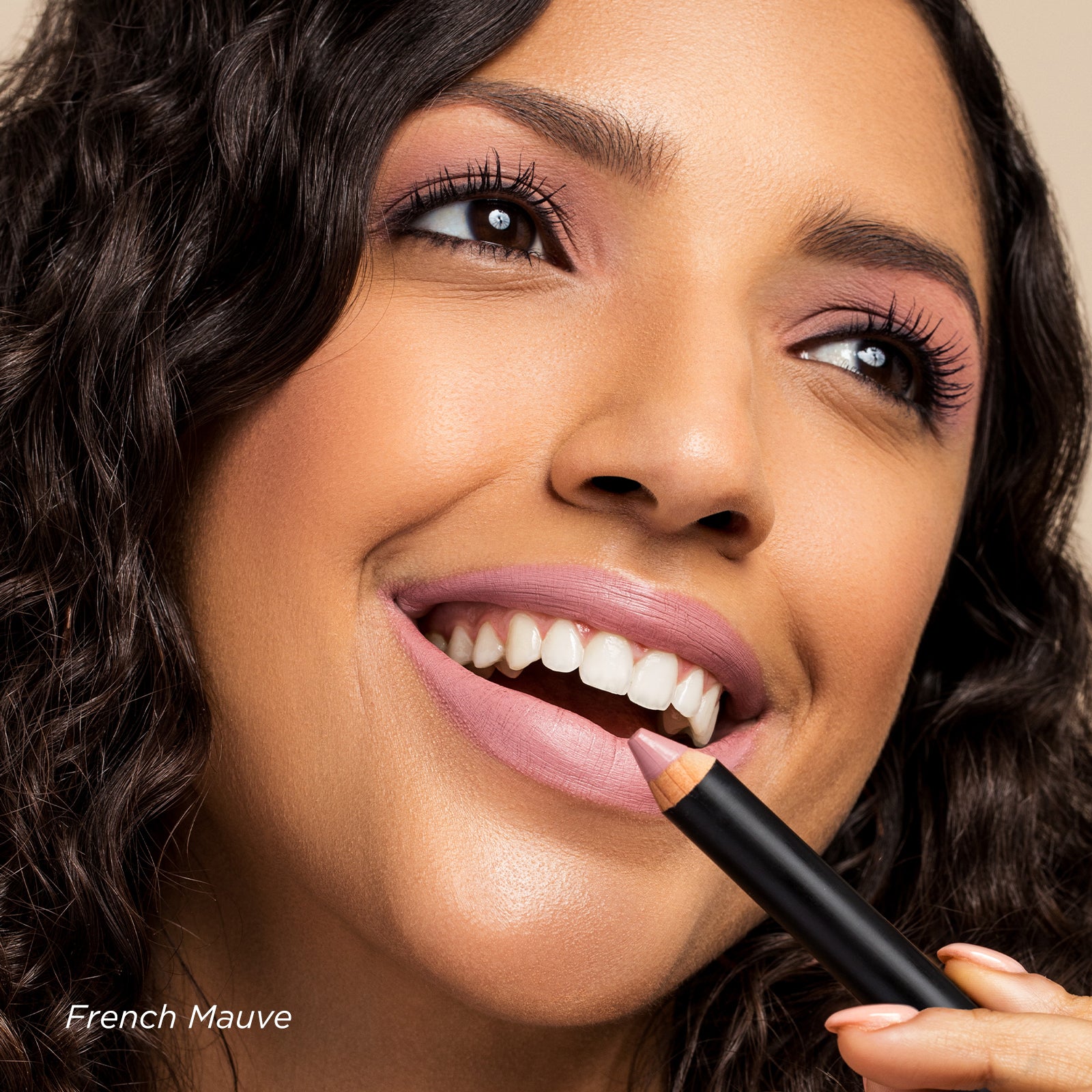 Woman applying lipstick with a focus on color 'French Mauve'.