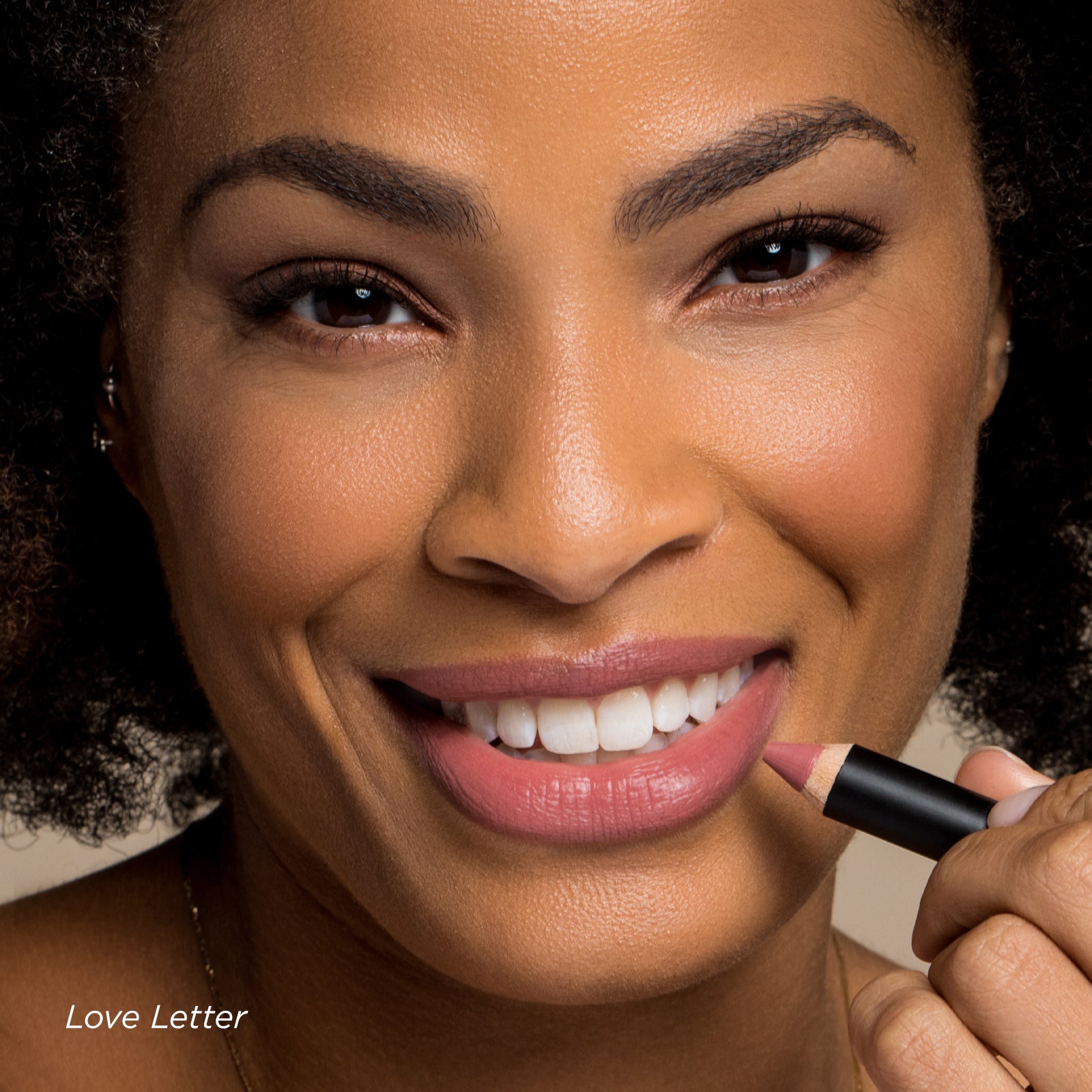 Woman applying lipstick with a focus on her face and the product.