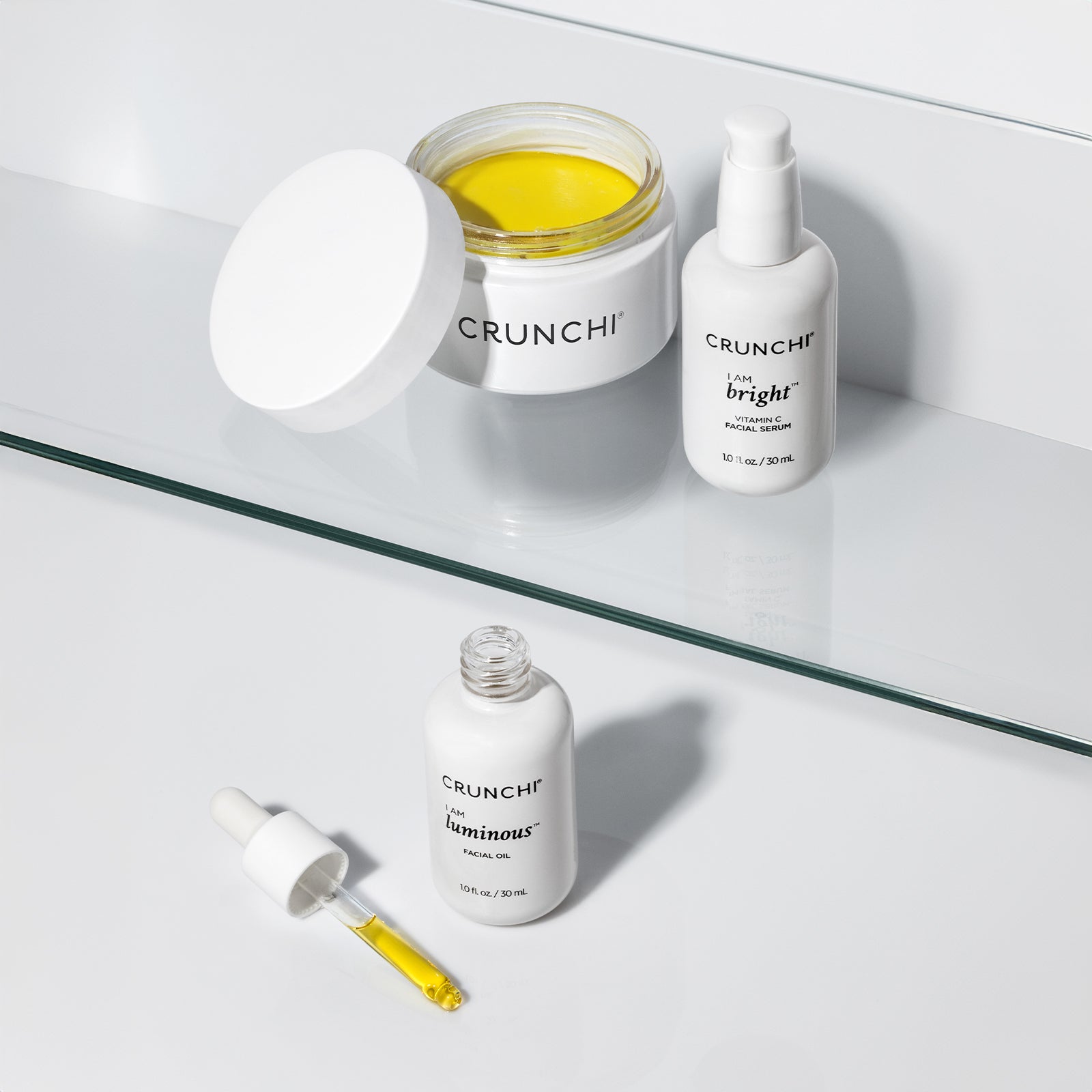 CRUNCHI skincare products on a glass shelf