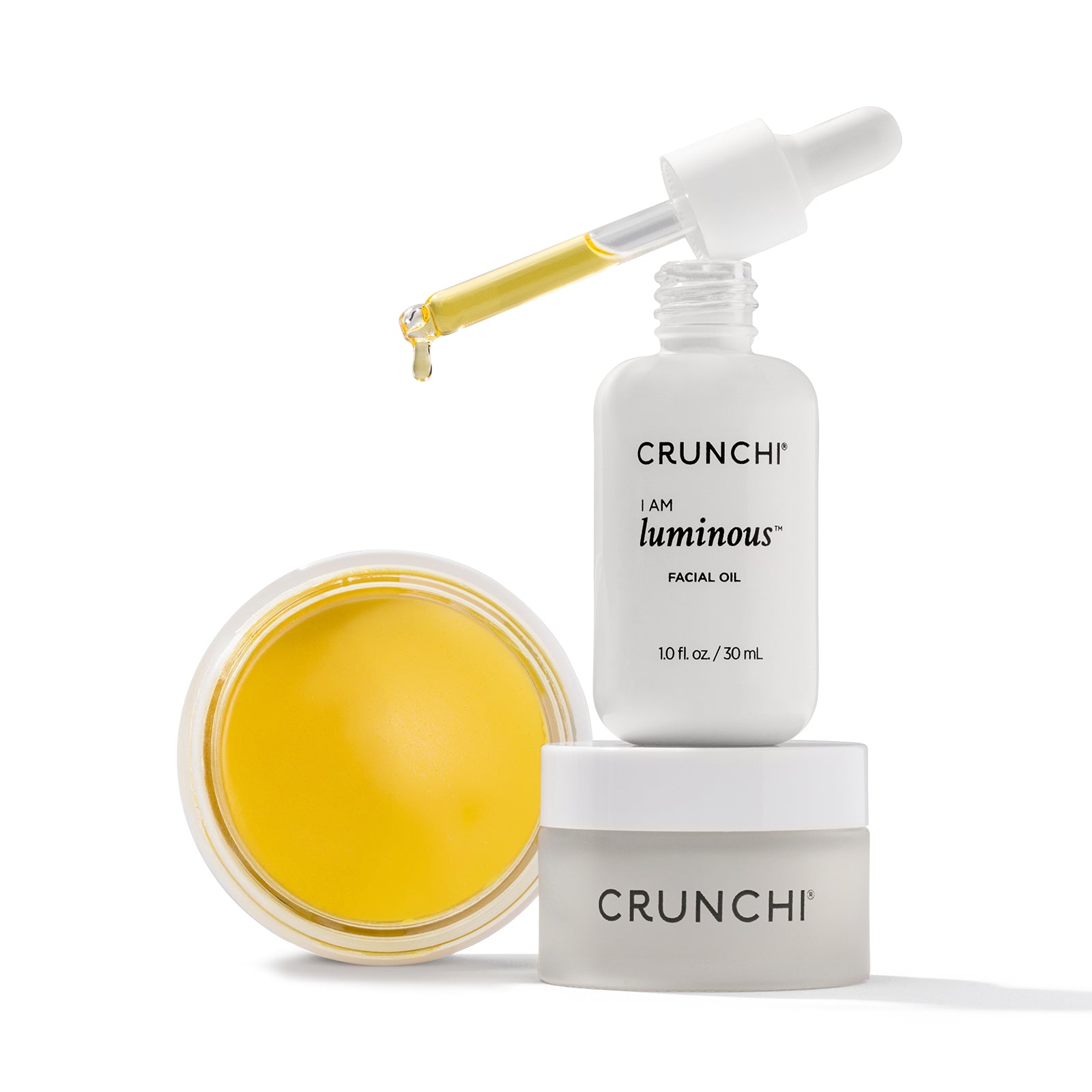 CRUNCHI facial oil, jar, and dropper on a white background
