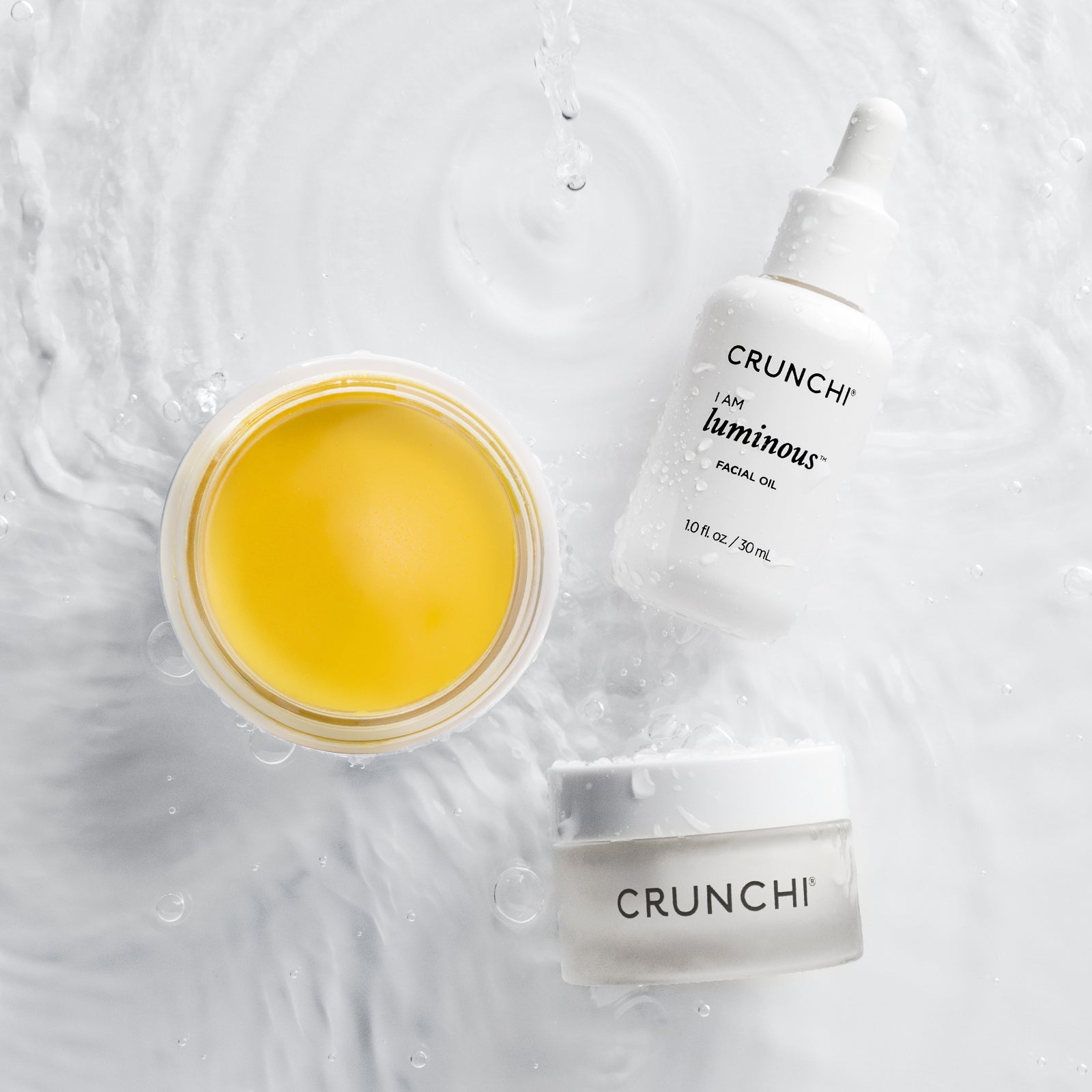 Three Crunchi skincare products on a textured white background