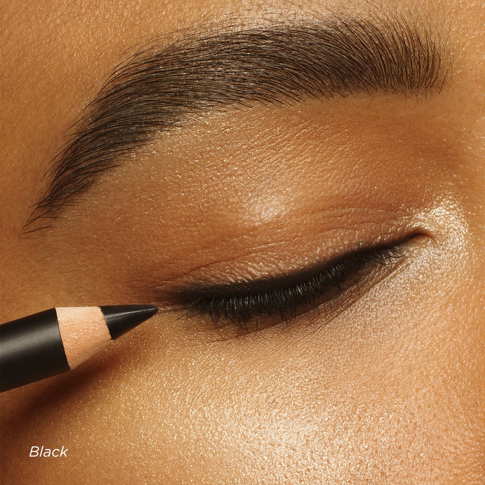 Eyebrow pencil being used on a person's eyebrow with close-up detail.