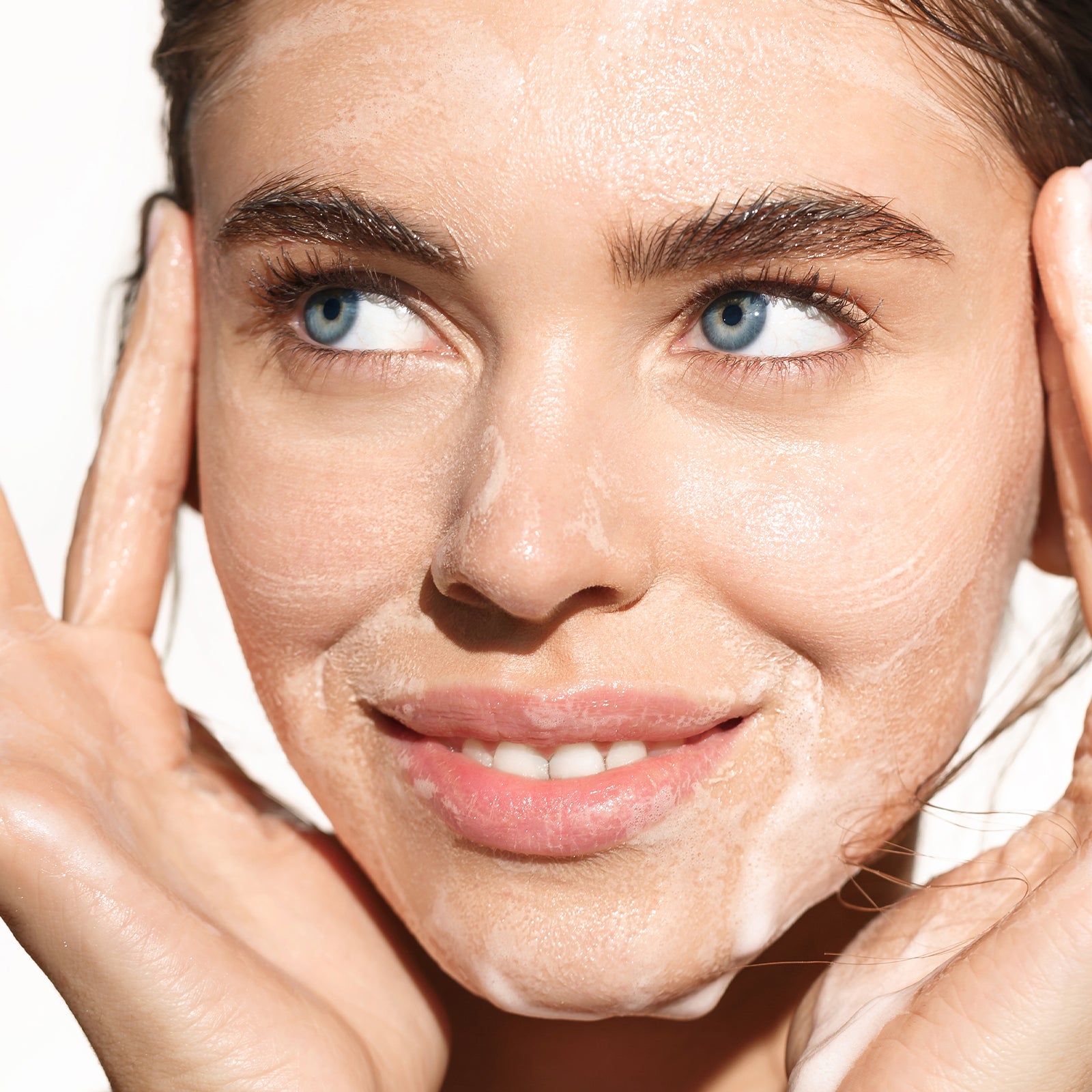 Close-up of a woman's face with clear skin on a white background