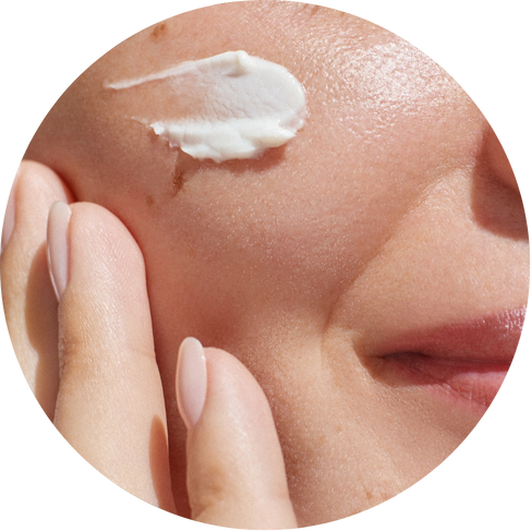 Close-up of a hand applying cream to skin